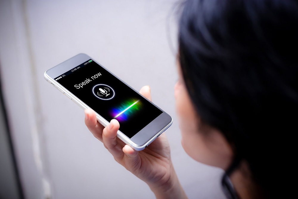 a person speaking into a voice assistant or typing on a smartphone, with AI-generated suggestion bubbles or icons a person speaking into a voice assistant or typing on a smartphone, with AI-generated suggestion bubbles or icons