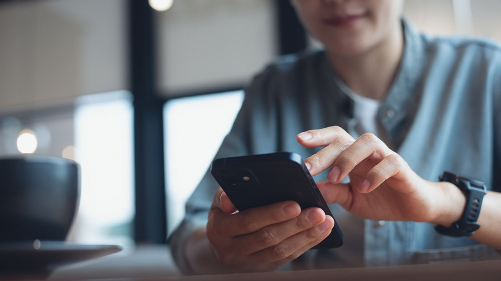 person browsing Facebook on a mobile device person browsing Facebook on a mobile device