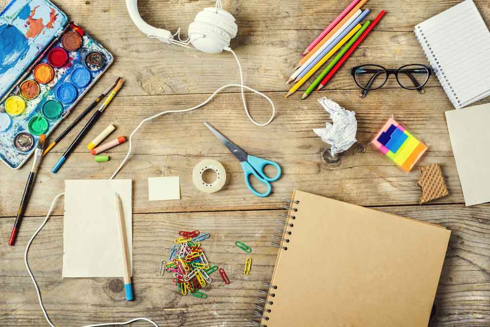 various art materials sprawled on top of a desk various art materials sprawled on top of a desk