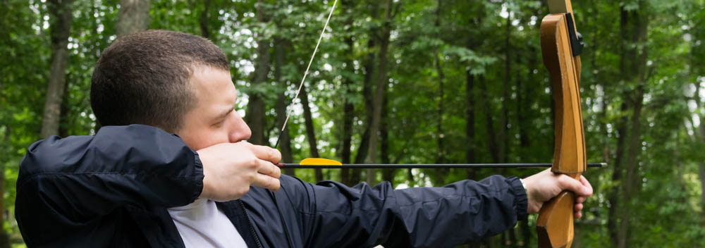 person pulling on an arrow’s bowstrings person pulling on an arrow’s bowstrings
